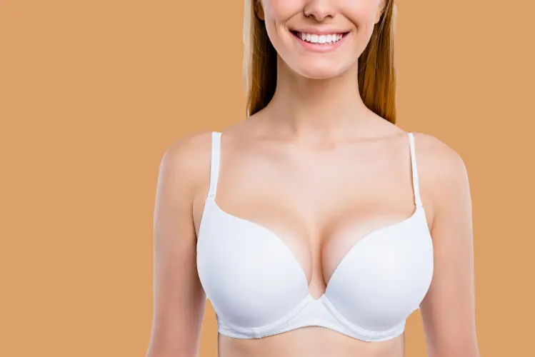 Cropped close-up portrait of nice confident attractive lovely cheerful cheery blonde, girl chest after uplift injection wearing bra isolated over light gray background